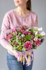 Beautiful bouquet of mixed flowers in woman hand. Floral shop concept . Handsome fresh bouquet. Flowers delivery. green and pink color.