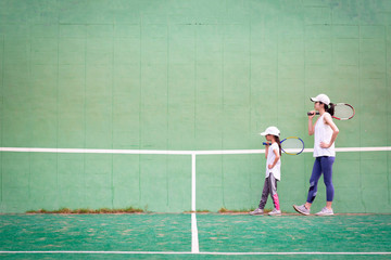 テニスの練習をする母と娘