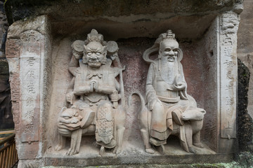 Fototapeta na wymiar Reliefs of Laozi (Lao Tzu) or Supreme Lord (right) and Mountain God (left) at Dazu Rock Carvings at Mount Baoding or Baodingshan in Dazu, Chongqing, China. UNESCO World Heritage Site.