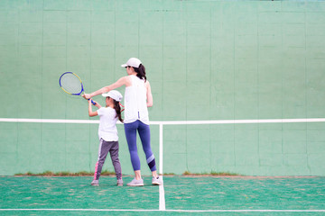 テニスの練習をする母と娘
