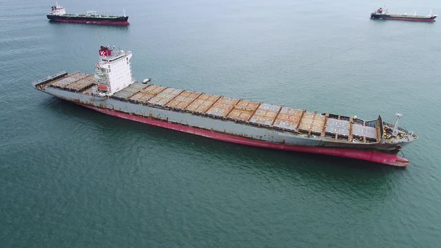 an aerial photograph of a bulk carrier anchored on the sea.