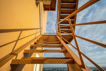 Fire escape stairs mounted to the outside, Emergency exit with yellow wall..