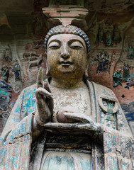 Giant statue of Buddha Sakyamuni on background of niche wall at Dazu Rock Carvings at Mount Baoding or Baodingshan in Dazu, Chongqing, China. UNESCO World Heritage Site. 