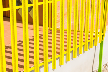 Yellow wooden fence and shadows from the sun light.