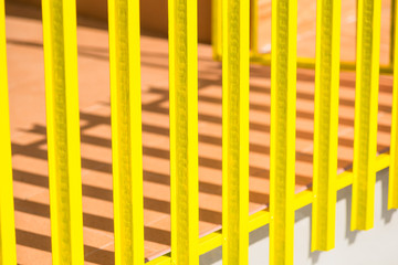 Yellow wooden fence and shadows from the sun light.