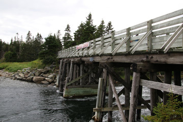 A wooden  bridge crossing a dangerously fast river
