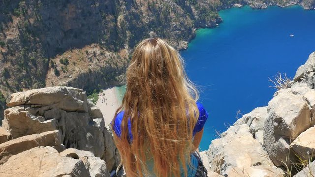 Woman traveller enjoying beautiful view of The Butterfly Valley from the top of the mountain