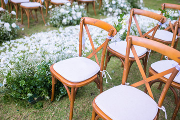 Chair decorated with flowers in Wedding ceremony.