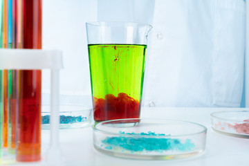Manipulations with laboratory glass chemical containers on table