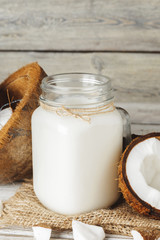 Coconut and coconut milk on rustic wooden table