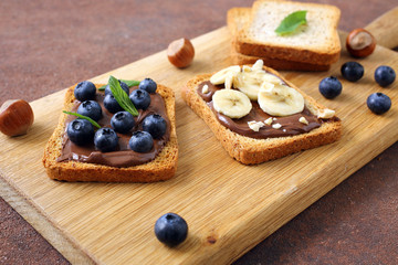 spuntino con cioccolato spalmabile su pane tostato con mirtlli e banane