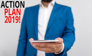 Word writing text Action Plan 2019. Business photo showcasing proposed strategy or course of actions for current year Business concept with man holding mobile phone with touch screen