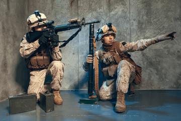 US special operations forces fighters armed with assault rifle, in opscore helmet. Studio shot
