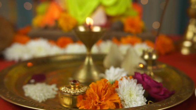 Close shot of a decorated temple for Ganesh Chaturthi - Modak  Lamp  Sweets  and Fruits. Pan shot of various items kept for worshipping Lord Ganesh in the temple - Puja thali  sweets  incense stick...