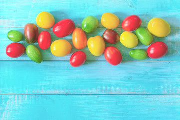 Fototapeta na wymiar colorful tomatoes on a wooden background. background with tomatoes. copy space. flat lay.