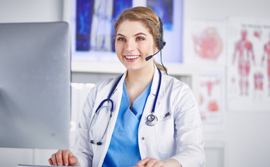 Portrait of a happy smiling young doctor in headset in office