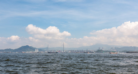 Fototapeta na wymiar Seascape viewed from Central/Western District Promenade, West Ring, Hong Kong. Stonecutters Bridge can be seen.
