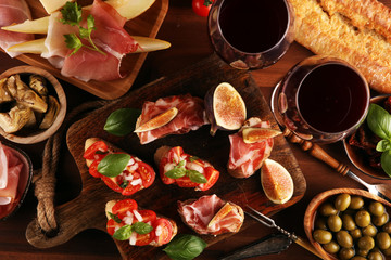 Italian antipasti wine snacks set. Cheese variety, Mediterranean olives, Prosciutto di Parma, tomatoes, artichokes
