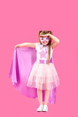 Cute little girl dressed as superhero on color background