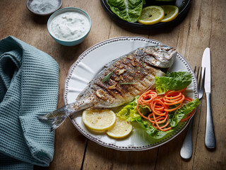 grilled fish on wooden kitchen table