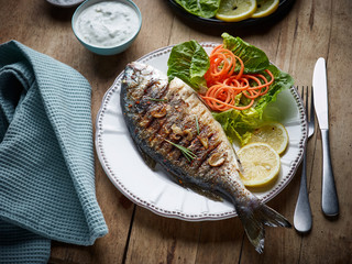 grilled fish on wooden kitchen table