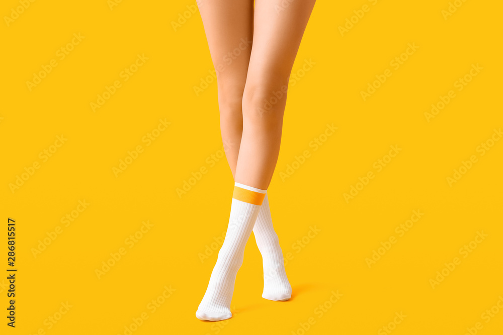 Wall mural legs of young woman in socks on color background