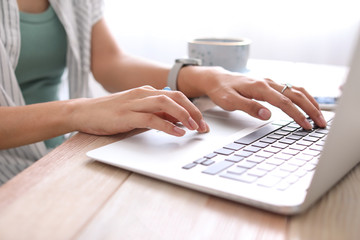 Blogger with laptop at table, closeup