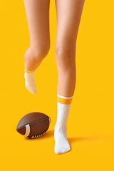 Legs of young woman in socks and with rugby ball on color background