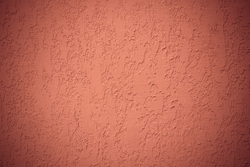 Red texture of wall. Ribbed surface of orange plaster. Corrugated concrete wall. Vignette of background. Modern paper design. Abstract pattern of stucco for banner.
