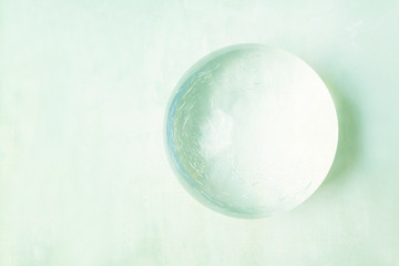 Fototapeta na wymiar glass ball on textured background - bright pastel tones