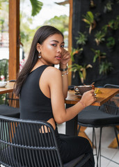Asian smile  girl  in a cafe. Beautiful Balinese women with a cup of coffee
