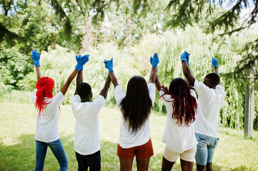 Back of group happy african volunteers hold hands together in park. Africa volunteering, charity,...