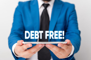 Handwriting text writing Debt Free. Conceptual photo does not owning any money or things to any individual or companies Businessman in blue suite with a tie holds lap top in hands
