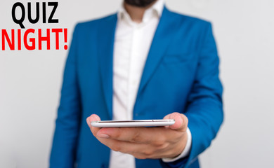 Word writing text Quiz Night. Business photo showcasing evening test knowledge competition between individuals Business concept with man holding mobile phone with touch screen