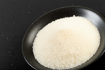 bowl of sugar  on black background