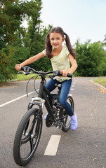 Fototapeta na wymiar Little girl riding bicycle outdoors
