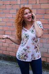 woman talking on mobile phone with brick wall background