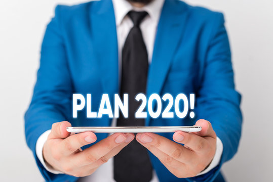 Handwriting text writing Plan 2020. Conceptual photo detailed proposal doing achieving something next year Businessman in blue suite with a tie holds lap top in hands