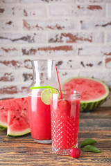 Glass and bottle of fresh watermelon juice on table