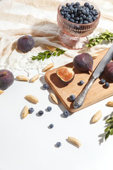 Figs, pear and blueberries on a cutting wooden board.