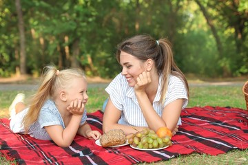 Happy mother and daughter at picnic outdoors