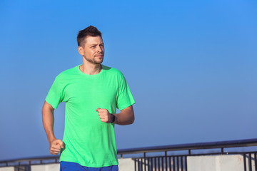 Handsome sporty man running outdoors