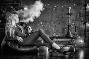girl smokes  hookah / beautiful glamorous girl in red dress smokes a hookah, the sexy model in a...