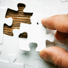 Hand with missing jigsaw puzzle piece. Business concept image for completing the final puzzle piece