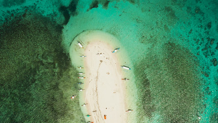 Sandy white island with beach and sandy bar in the turquoise atoll water, aerial drone.Tropical island and coral reef. Naked Island, Siargao.