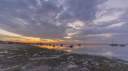 Sunrise timelapse cloudy seascape, in Ria Formosa wetlands natural park, shot in Cavacos beach. Algarve. Portugal.