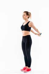 Fototapeta na wymiar Young sporty blond woman in a black sportswear stretching before exercising isolated over white background.