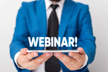 Handwriting text writing Webinar. Conceptual photo seminar or other presentation types that takes place on Internet Businessman in blue suite with a tie holds lap top in hands