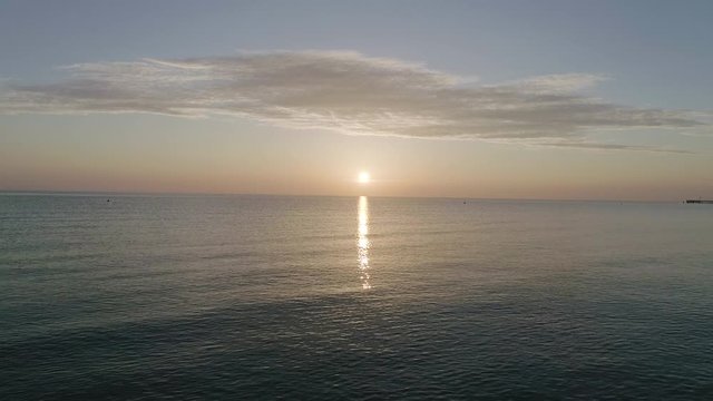 Flying Towards Sunset in Horizon over Water