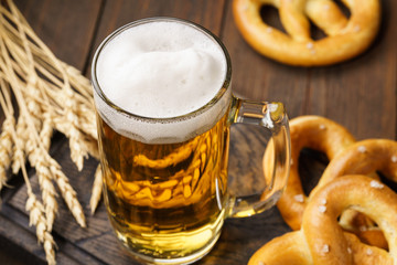 A mug of lager beer with german pretzels.